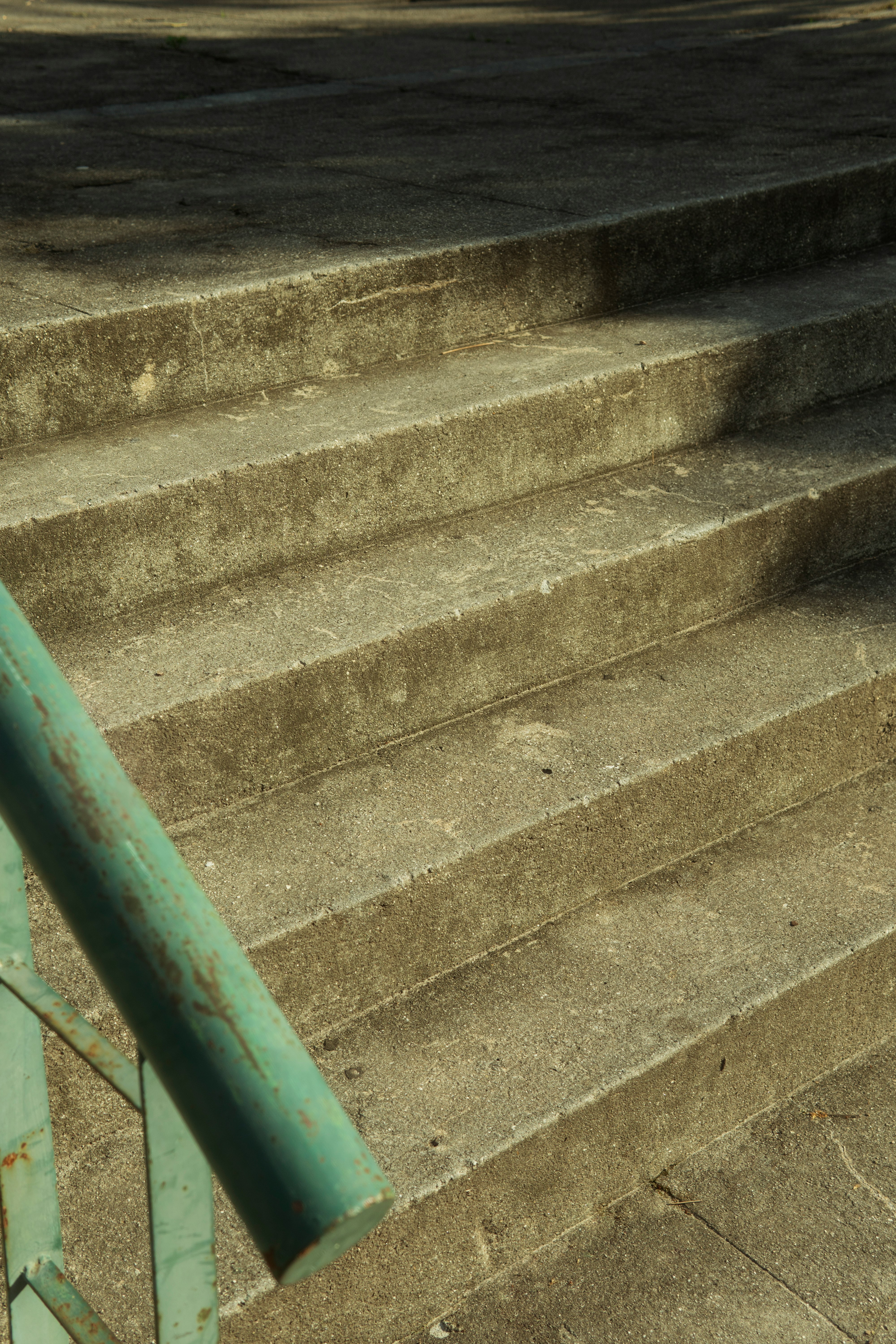 green metal railings on gray concrete staircase